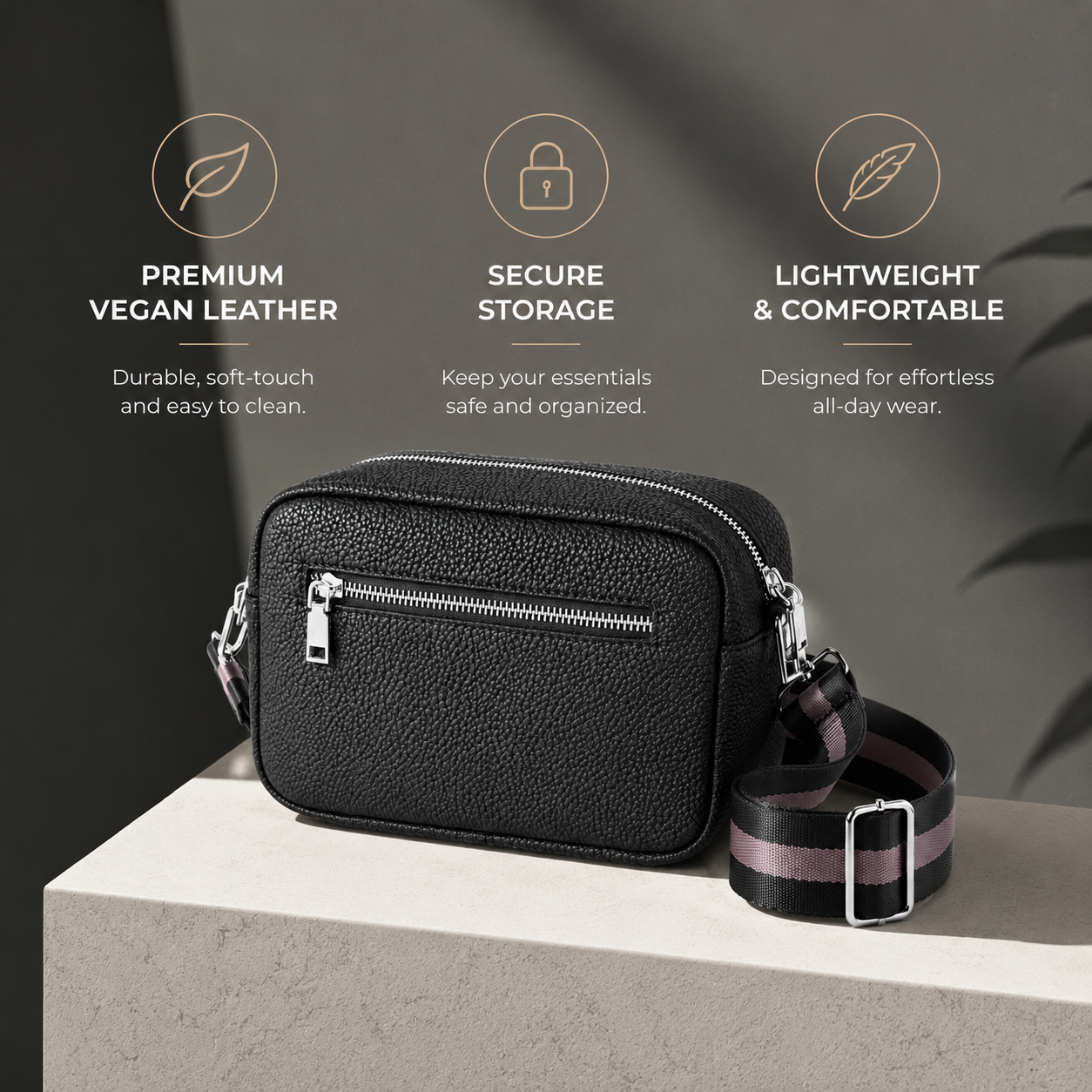 Informative graphic of a black camera-style crossbody bag on a grey stone surface. The top section features three icons highlighting its features: "PREMIUM VEGAN LEATHER", "SECURE STORAGE", and "LIGHTWEIGHT & COMFORTABLE